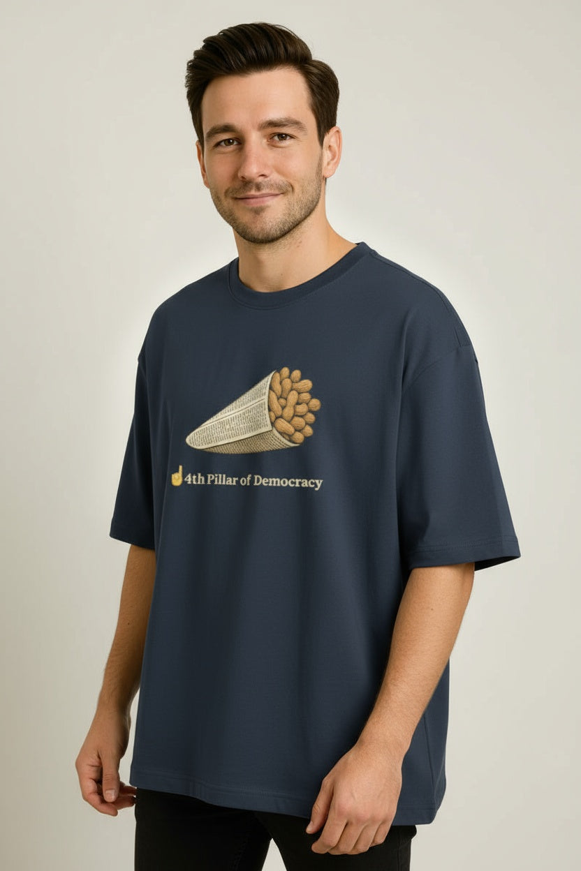 Man wearing a navy blue t-shirt with a graphic design on a plain background